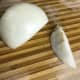 Trim the ends of the onions, split them in half, and remove the outer layer. If you have any root ends left on like the one in the photo, be sure to trim them out at a diagonal. If they are left intact, the onion layers will not separate properly.
