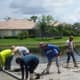 Here the workers are leveling the concrete as it was being pumped into the area. The edges were previously defined with boards and stakes to contain the concrete. The proper slope was determined at that time.