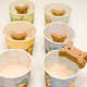 Gently place a dog biscuit into the center of each cup's mixture.
