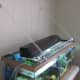 A cheap Menards wire shelf with an added nylon string to keep it in place.