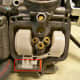 Remove the pin that holds the float in place (circled in red). Remove float and float valve.