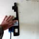 Holding the mounting bracket to the wall to mark the holes for drywall anchors. A level was used to assure it was vertical.