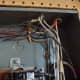 Wires entering the panel through cable clamps.