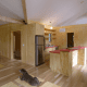 This kitchen demonstrates the heavy emphasis on natural wooden surfaces integrated into the rustic-feeling interior design. Those panels under the dog are under-floor storage.