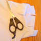 Cut slits into both sleeves of the shirt.