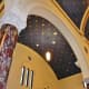 Partial view of arches, ceiling, and stained-glass windows
