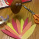 Cut out feathers from construction paper. Tape together in a fan shape and attach to back of potato using peanut butter.