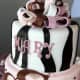A cake in a striking black, white, brown, and pink theme.