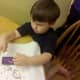 My son using a glue stick to attach the colored circles to his octopus.