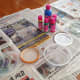 Cover work area with newspaper. Gather 1 small glass jar, and 5 shallow plastic lids to hold the 5 colors of fabric paint.