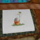 Assembling the fabric frame around the cross stitch, one layer at a time.