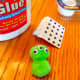 Glue 2 green pom poms together and attach googly eyes to make alien.