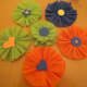 Rosettes embellished with paper shapes.