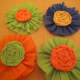 These rosettes are embellished with rolled flowers made from crepe paper.
