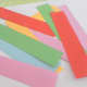 Coloured craft paper cut into strips and ready for making the paper hearts.