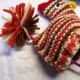 Pull the long ends of the tie on the pom to the inside through the back end.