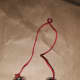 Tie little bells on red yarn or string.