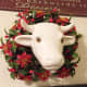 Wall Cow with a plastic wreath around its neck