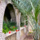 The open arches in the walkway look out into the shaded courtyard on both sides.