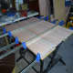 Clamping the doweled panel together (keeping it flat) until the glue dries.