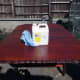 Cleaning table top with white spirit after light hand sanding, prior to applying final coat of wood stain.