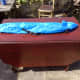 Redundant blue carry bag for broken folding chair repurposed as storage bag for the removable table arms and Chrome legs for drop leaf table top support.