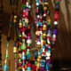 My own beaded curtain is made of glass, plastic and handmade polymer beads, along with fabric to fill in spaces, all threaded with fishing line.