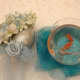 A fish bowl and shell flower vase for each individual wedding reception dinner table.