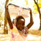 A girl carrying her OCC shoebox on her head in Cameroon.
