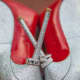 Gorgeous wedding rings on silver high heel shoes with red lining