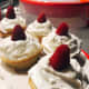 Fluffy and soft vanilla cupcakes with simple vanilla frosting topped with red raspberries 
