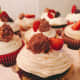 Scrumptious chocolate cupcake with vanilla frosting, freshly sliced strawberries, and Ferrero Rocher chocolate hazelnut