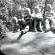 "Billy, Tommy, Peggy & Johnny on rock in park below Devils Tower"