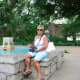 My mom sitting near a fountain on the grounds of the Alamo