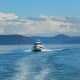 A C-Dory, a small pocket cruiser, crossing Rosario Strait, with some of the San Juan Islands in the background.