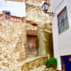 Street view from the upper part of the village, with steps and contrasting walls of rough stone against whitewashed walls.