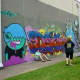 People admiring graffiti murals across from Baldwin Park