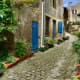 A narrow cobblestone street, weaving between old stone houses that seem unchanged for hundreds of years.