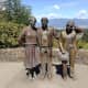 Photo Session is a life-size bronze sculpture of a man photographing three people. Vancouver and a city on the other side of Burrard Inlet are visible in the background.