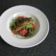 Mackerel fillet is laid on the salad bed and is ready to be garnished and served