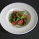 Salad leaves and red grapefruit segments are combined and laid as a salad bed in the serving plate