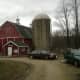 The milkhouse is the small red building in front of the barn.  Taken in 2010.