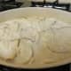 Half of the béchamel sauce over the potatoes and onions