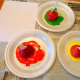 Cut apples in half and squirt out green, red, and yellow paint on paper plates.