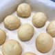 Arrange the dough balls on a baking pan that is lined with parchment paper. 