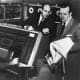 Mr. Eckert (Center) with Walter Cronkite in a UNIVAC demo. 