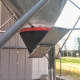 A slide gate allows grain to be emptied into a boat-type hopper used with a transport auger.