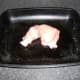 Chicken is wrapped in bacon and placed on an oiled baking tray