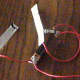 Attach the the stripped end of the third copper wire to the light bulb and socket. Attach the other stripped end of the wire to the second electrode. Your salt water circuit is ready to use.