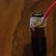 Attach the stripped end of one copper wire to the positive end of the battery.